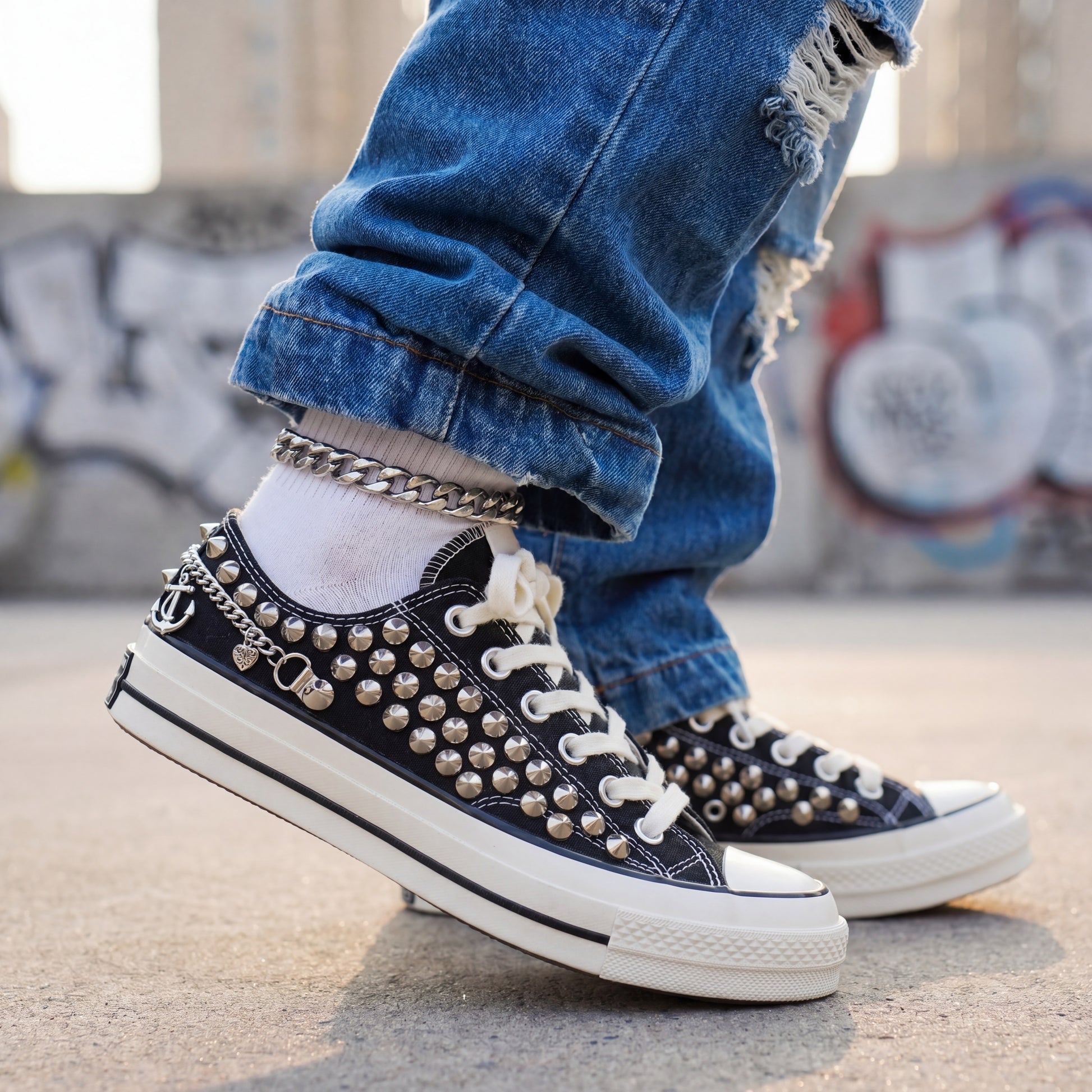 Black studded low top Converse sneakers with silver anchor charms