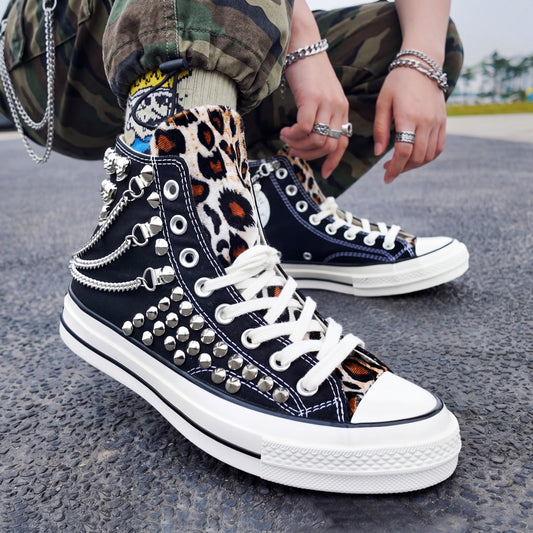 Black studded high top Converse sneakers with leopard print tongue