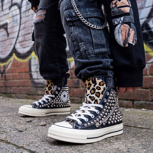 Black studded high top Converse sneakers with leopard print tongue