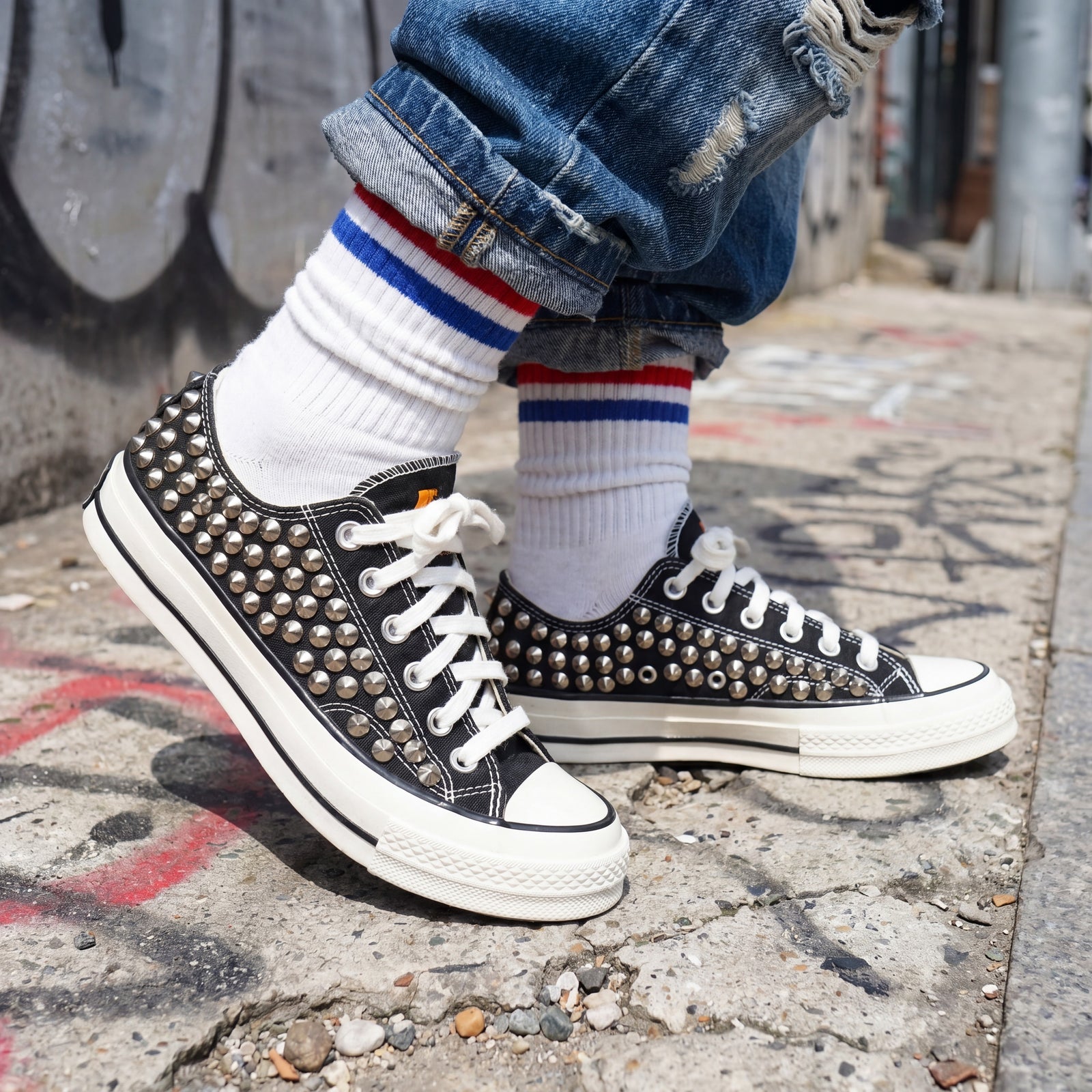 Black studded low top Converse sneakers with leopard print tongue
