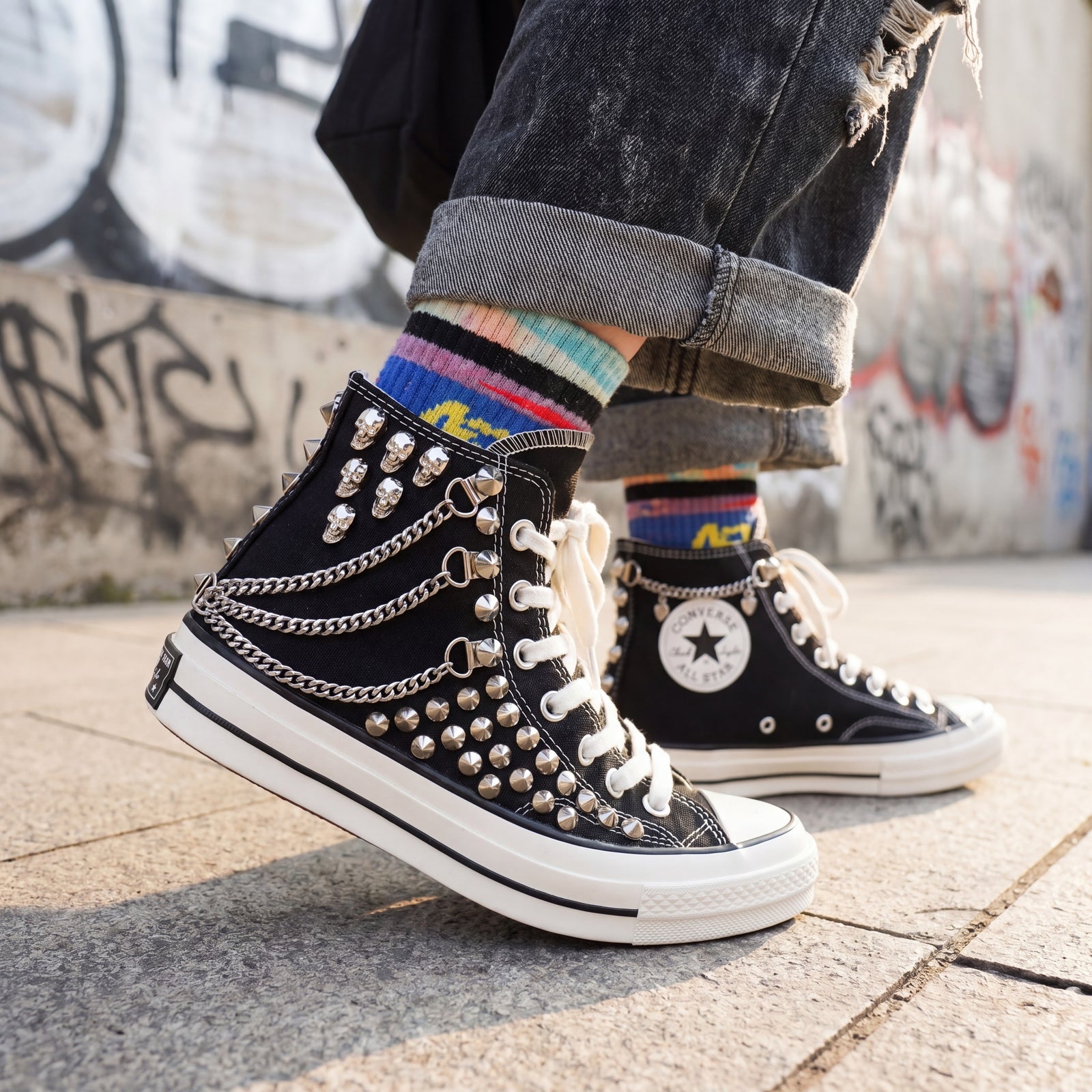 Black studded Converse sneakers with skull charms for bold street style