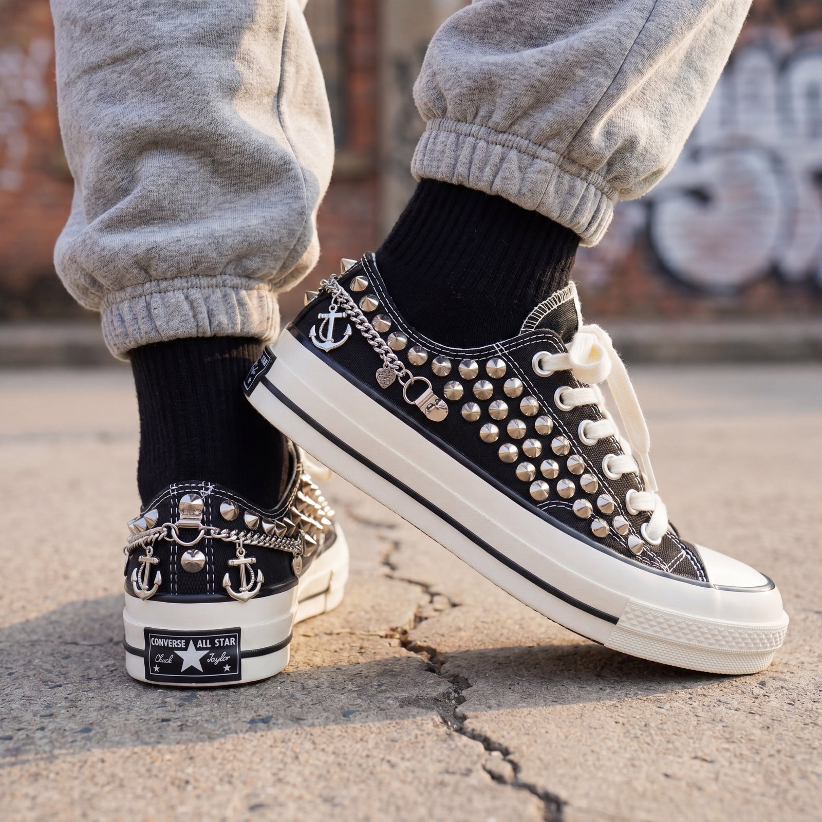 Custom studded low top Converse sneakers styled with denim jogger pants