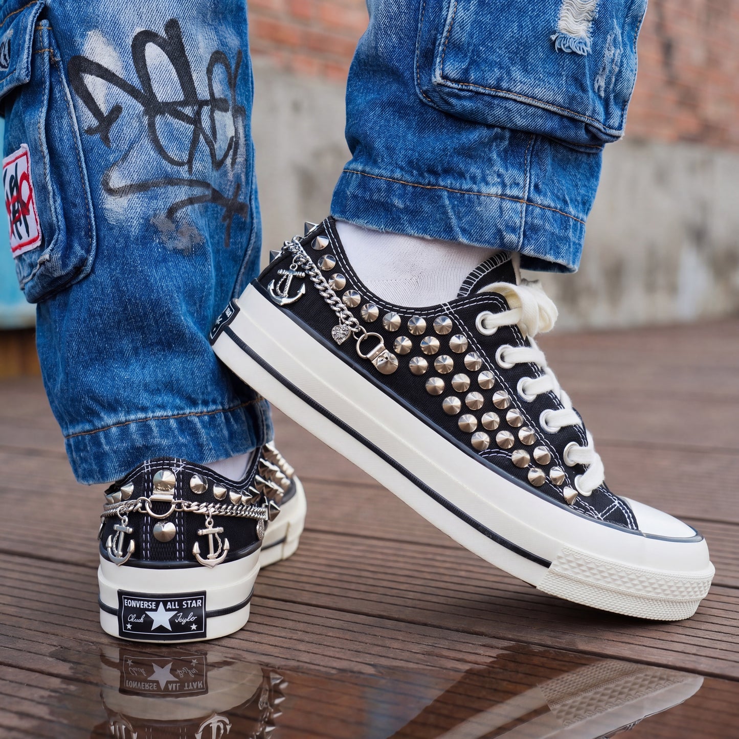 Edgy black Converse low top sneakers with silver hardware and white rubber sole