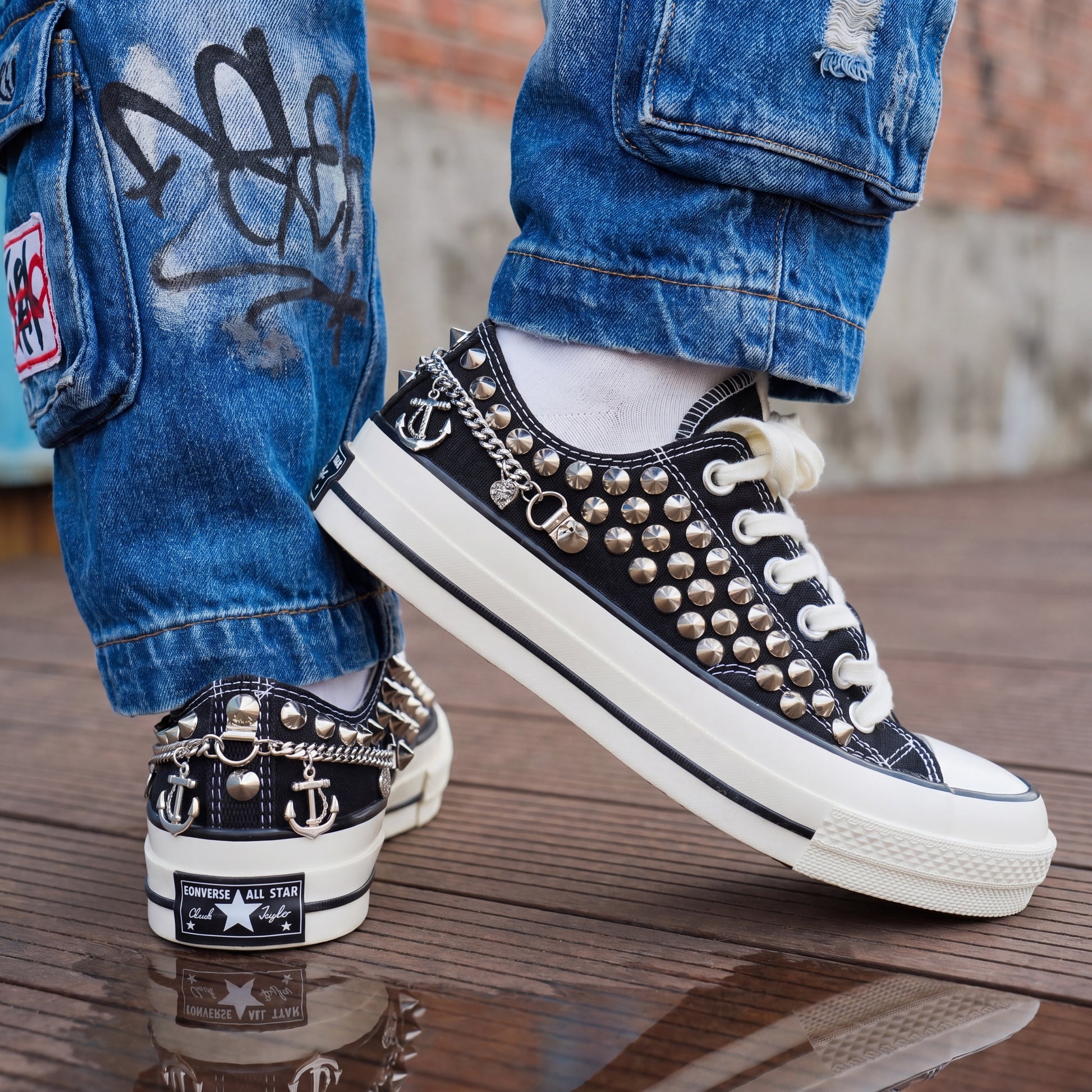 Edgy black Converse low top sneakers with silver hardware and white rubber sole