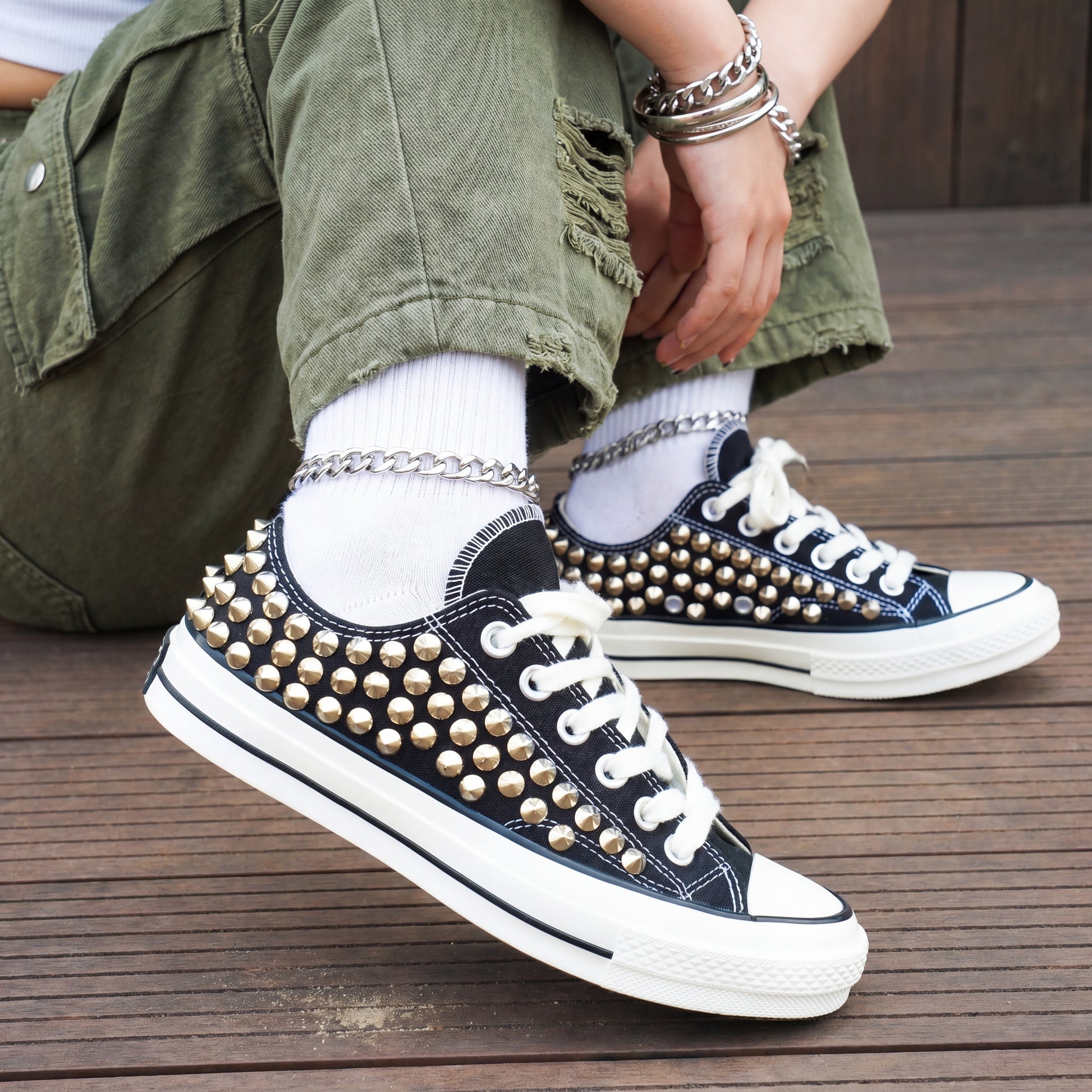 Black studded low top Converse sneakers with silver spikes