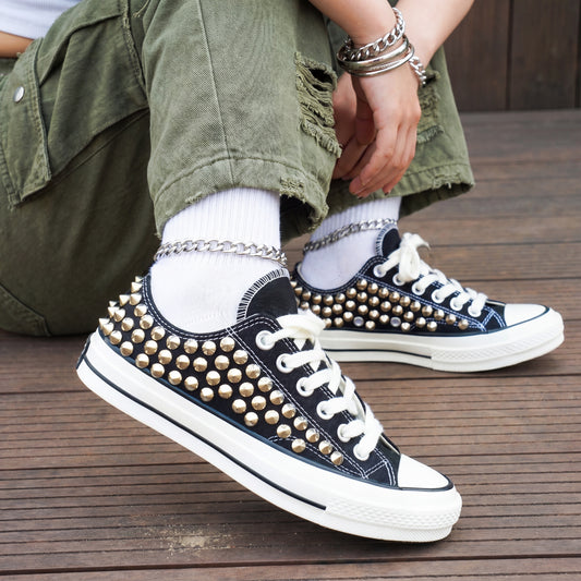 Black studded low top Converse sneakers with silver spikes