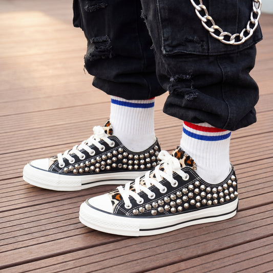 Edgy low top sneakers with metallic studs and classic rubber sole