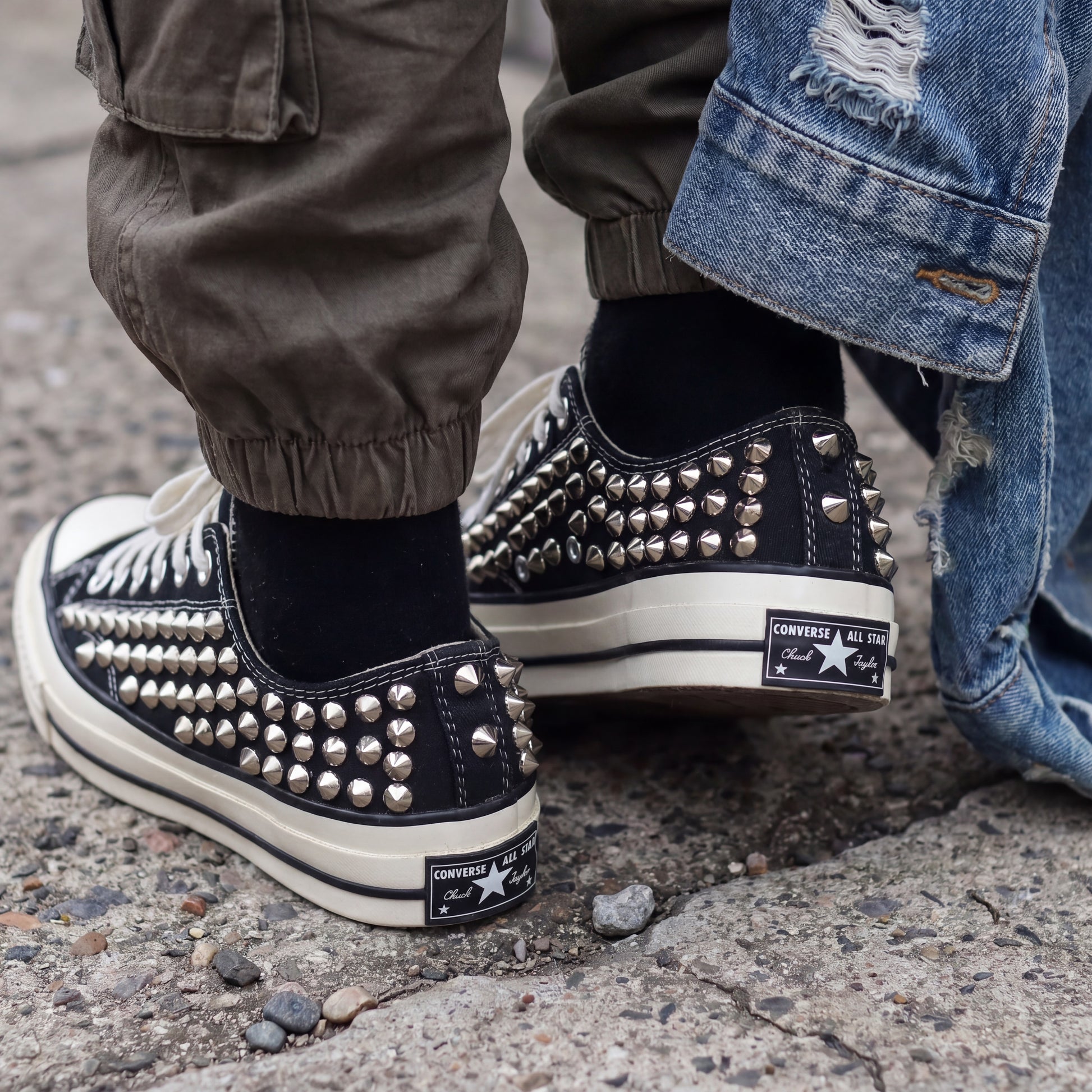 Black Converse sneakers with silver spikes and classic white laces