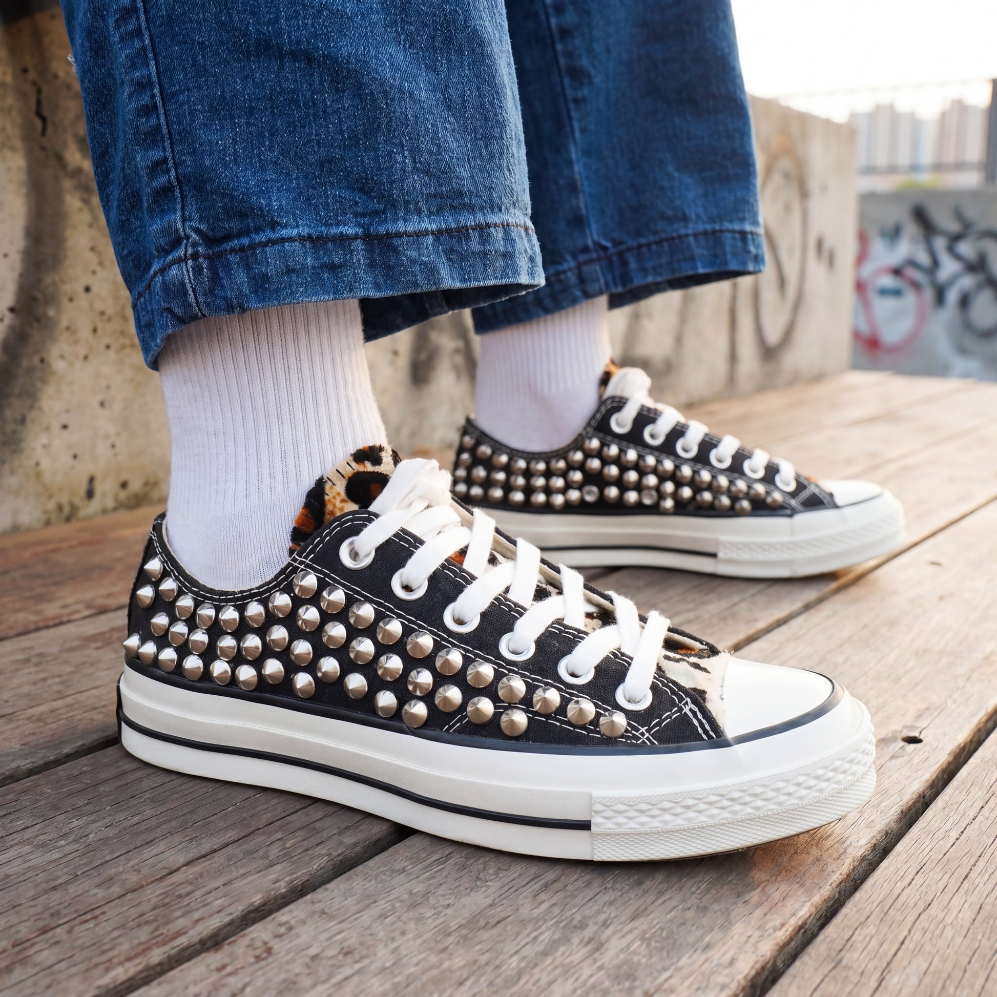 Black studded low top sneakers with silver metal spikes and white laces