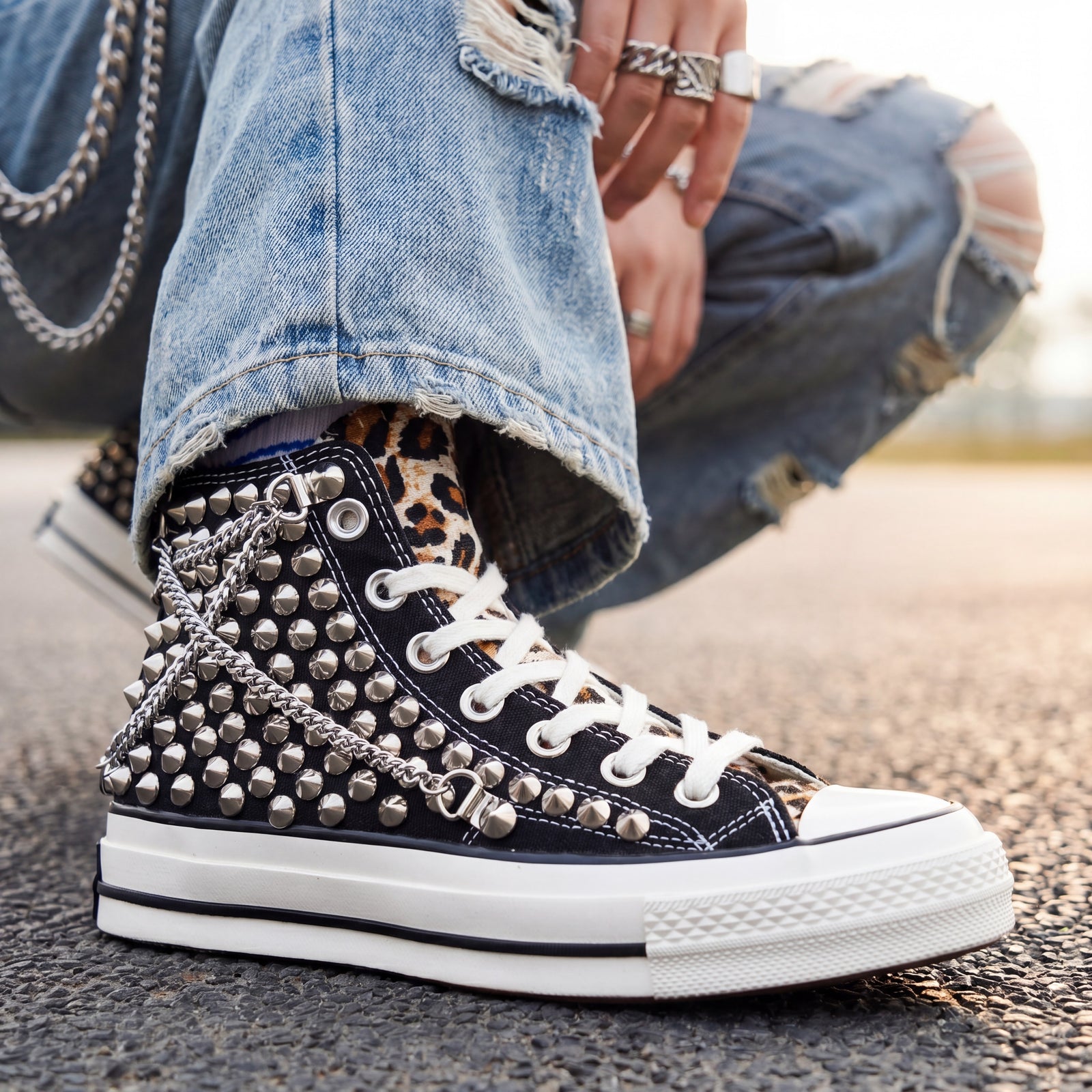 Black Converse high top sneakers with leopard tongue and chain accessories