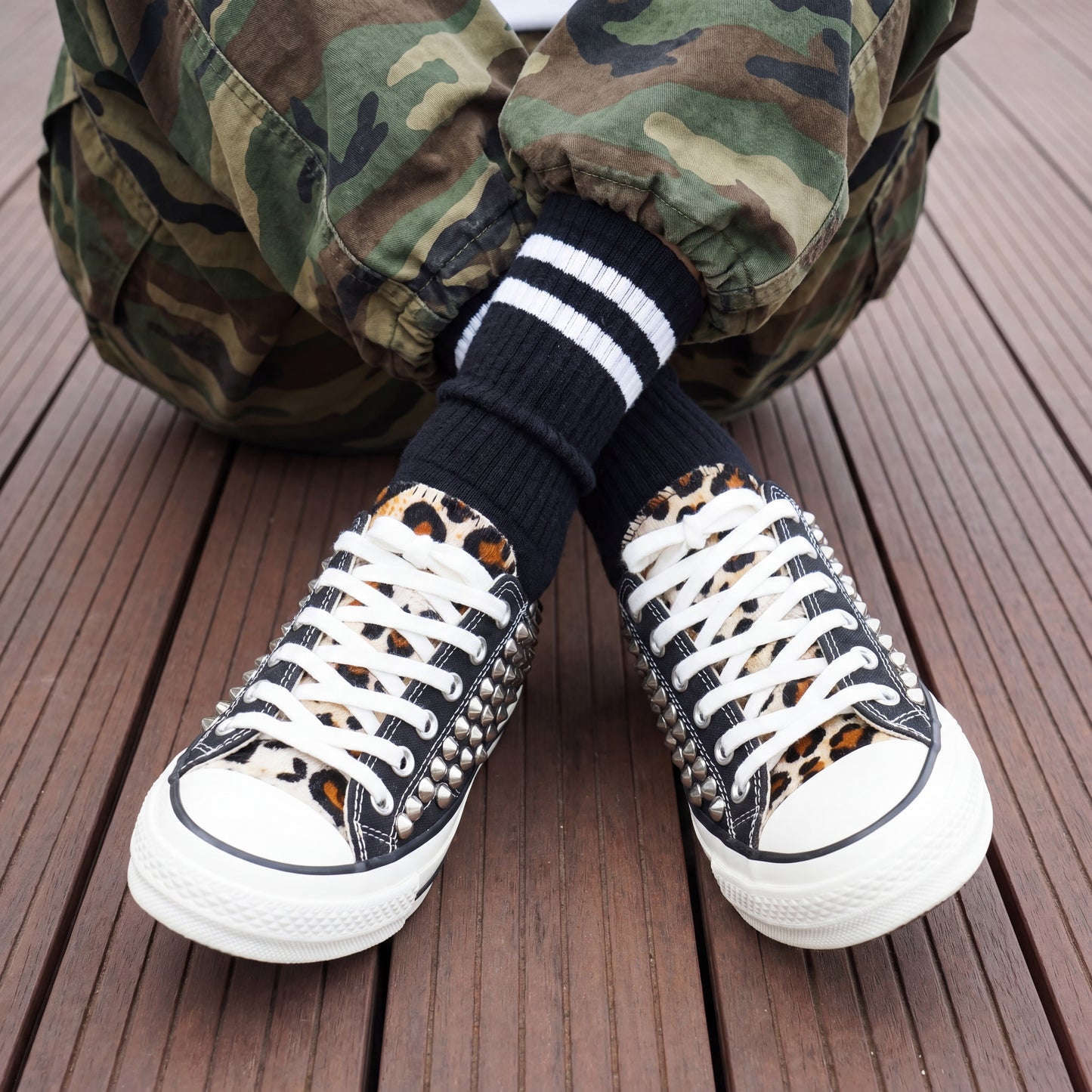 Streetwear fashion sneakers with black canvas upper and metal studs
