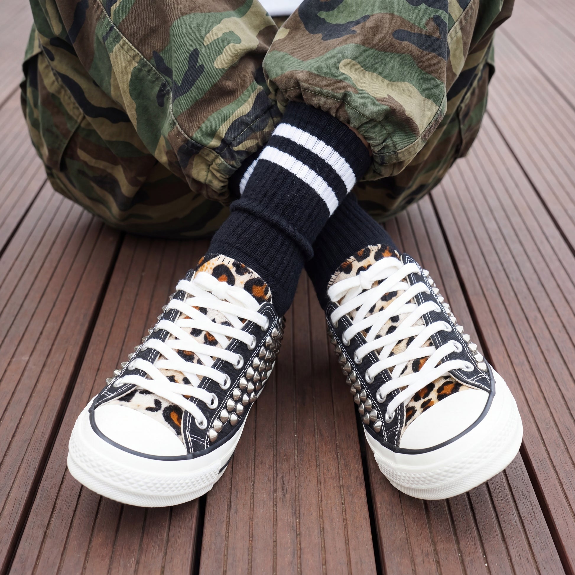 Streetwear fashion sneakers with black canvas upper and metal studs