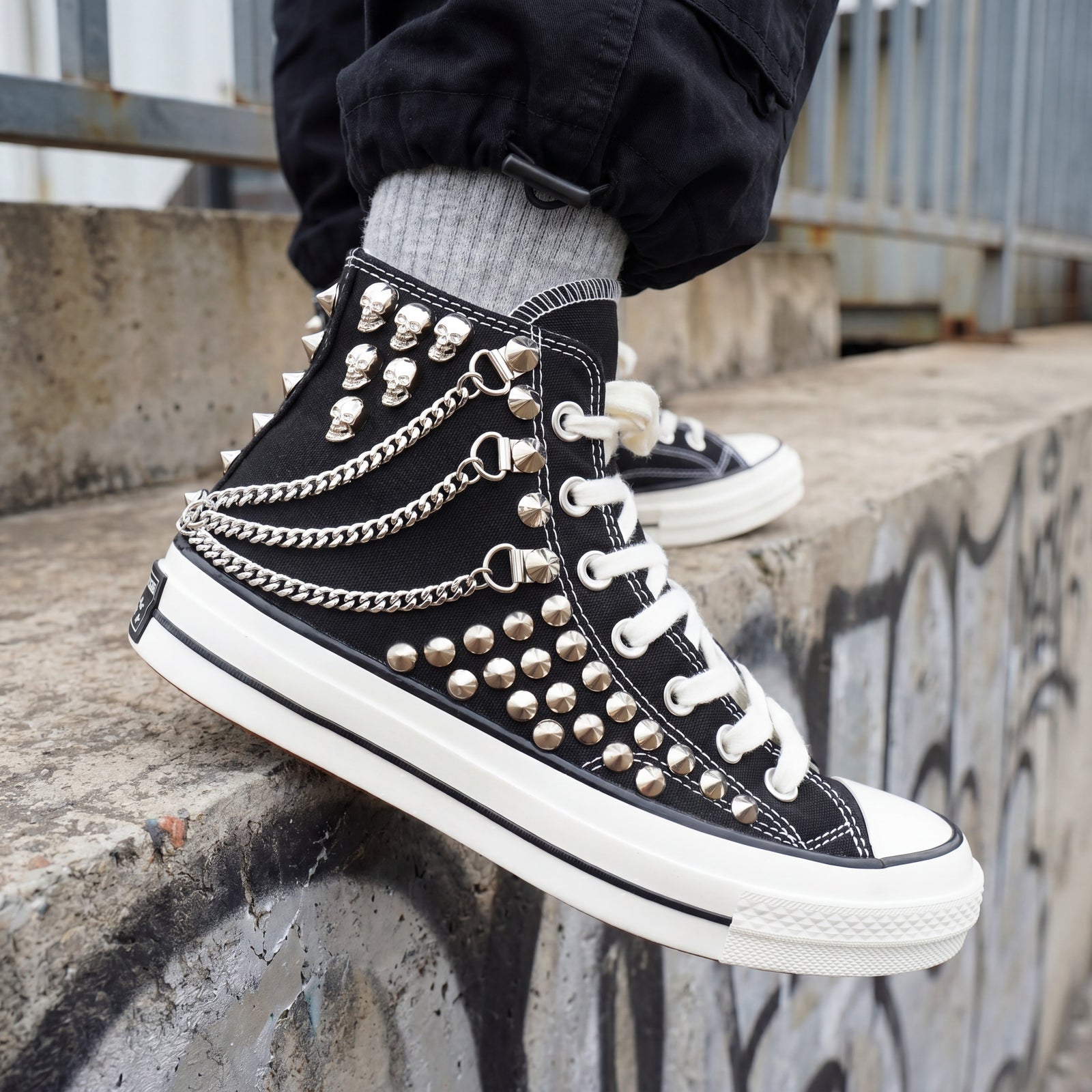 Black Converse high top sneakers with silver chains and skull decorations