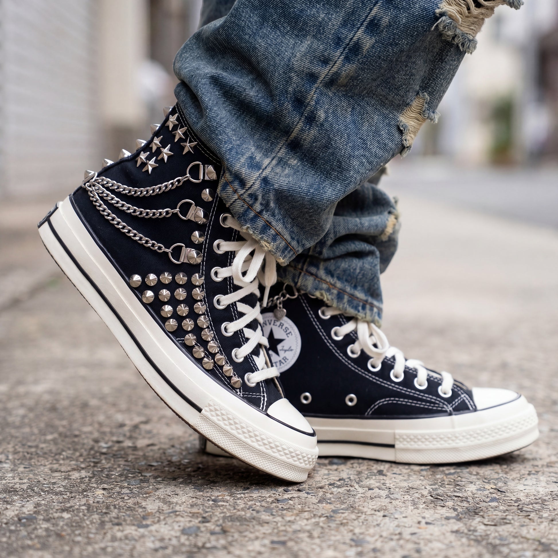 Black studded high top Converse sneakers with silver chains and star charms