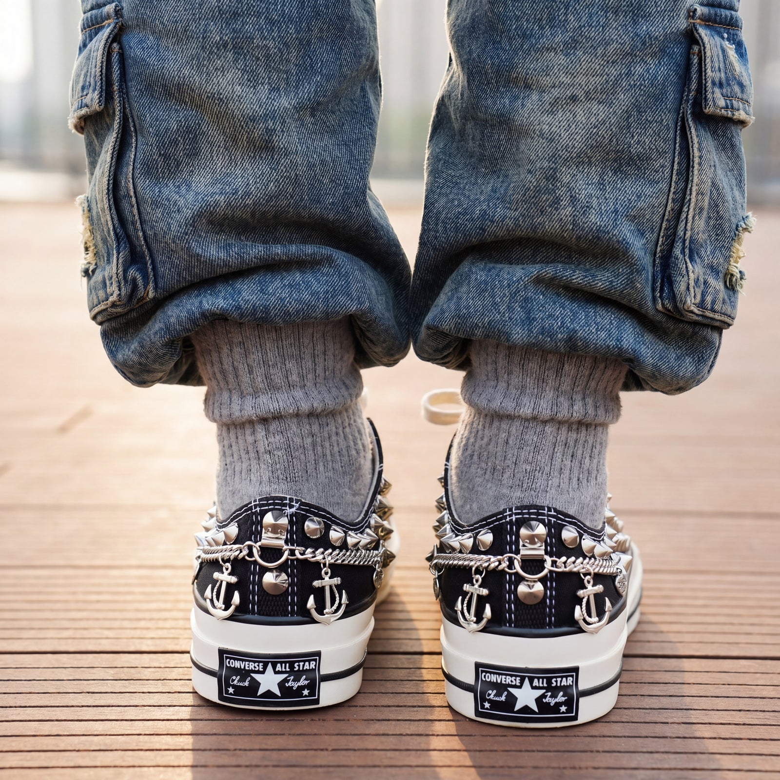 Black Converse low top sneakers with silver anchor charms and white laces
