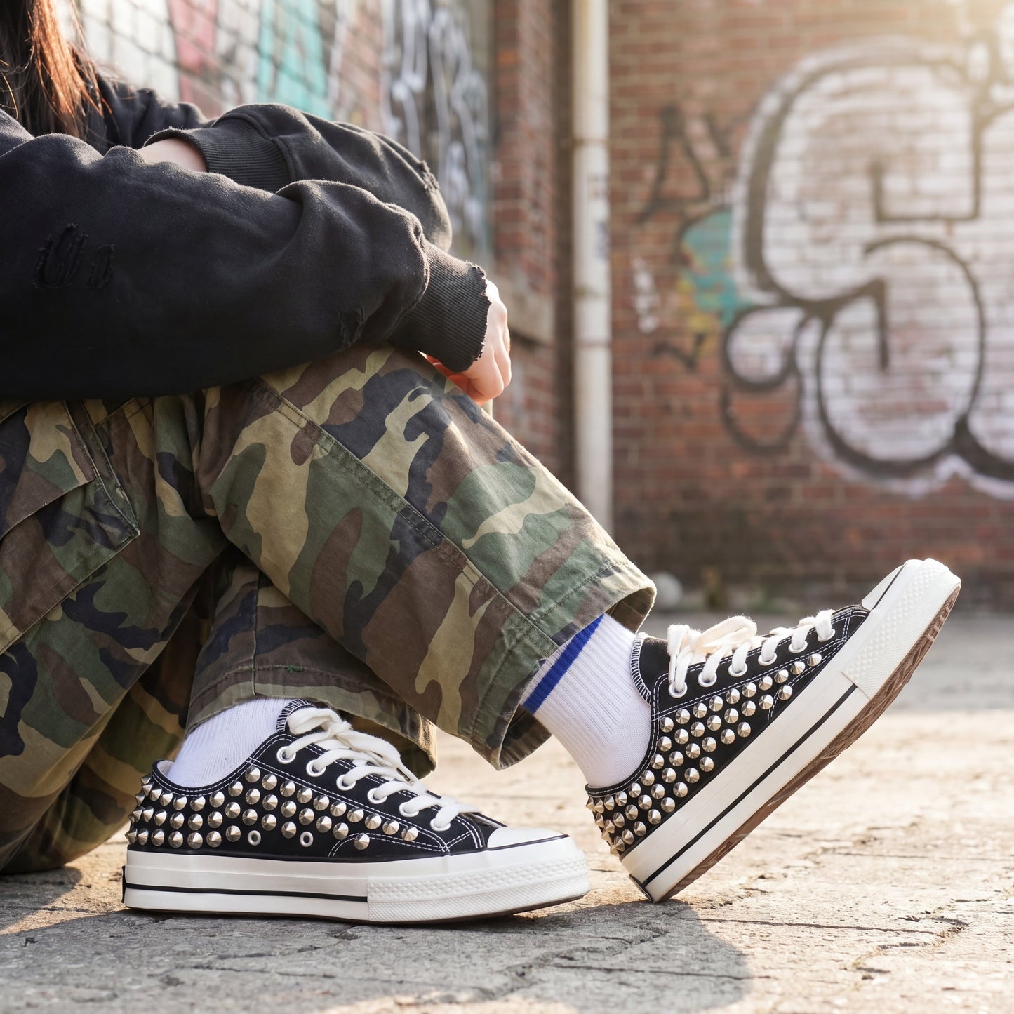 Black low top canvas sneakers with silver spikes for streetwear fashion
