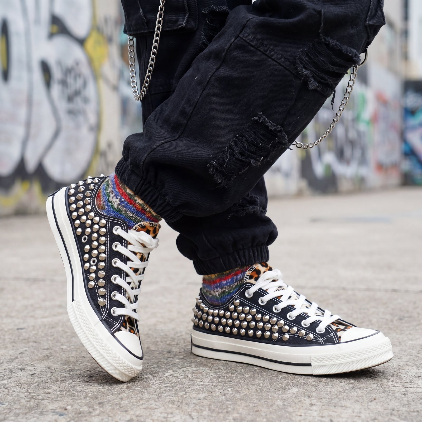 Custom black Converse low top shoes with silver studs and white laces